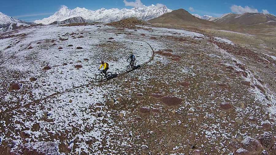 Bird's eye view of two mountain bikers in Muktinath, Mustang.